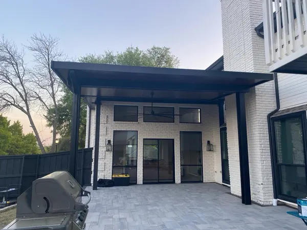 Black modern flat patio cover with ceiling fan on a white brick home — CertiPro project, DFW