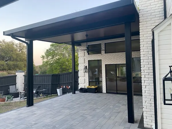 Black modern patio cover with lantern lighting over a walkout paver patio — CertiPro project, DFW
