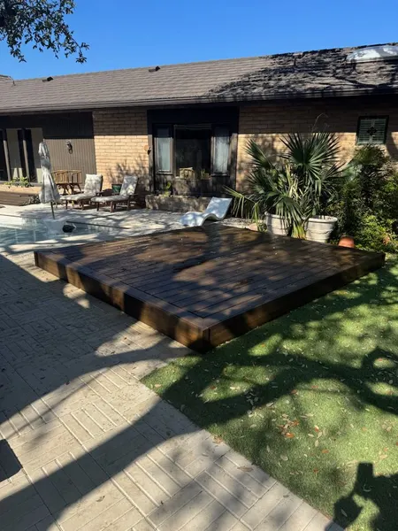 Custom floating hardwood deck beside patio seating area — CertiPro project