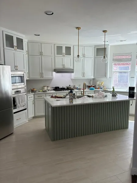 White kitchen remodel with fluted sage-green island and brass fixtures — CertiPro remodel